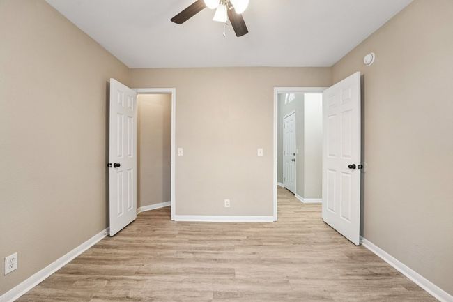 Unfurnished bedroom with light wood-style flooring and ceiling fan | Image 14