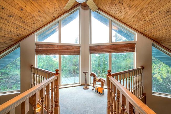 Corridor with vaulted ceiling, wooden ceiling, plenty of natural light, carpet, and an upstairs landing | Image 24