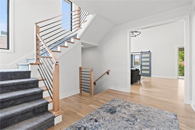 Stairway with wood finished floors and a barn door | Image 23