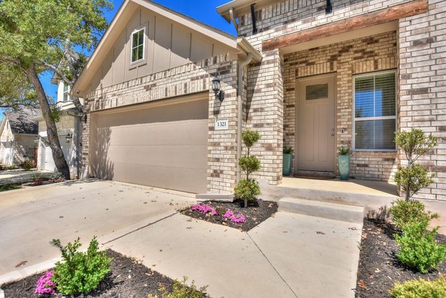 Property entrance with concrete driveway, brick siding, board and batten siding, and a garage | Image 30