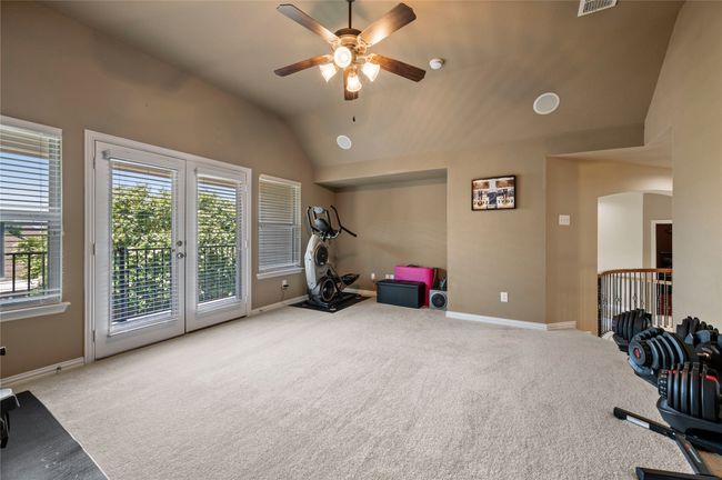 Exercise area with carpet flooring, a ceiling fan, lofted ceiling, and arched walkways | Image 28