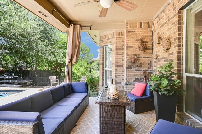 Covered porch that overlooks the pool and fenced backyard. | Image 23
