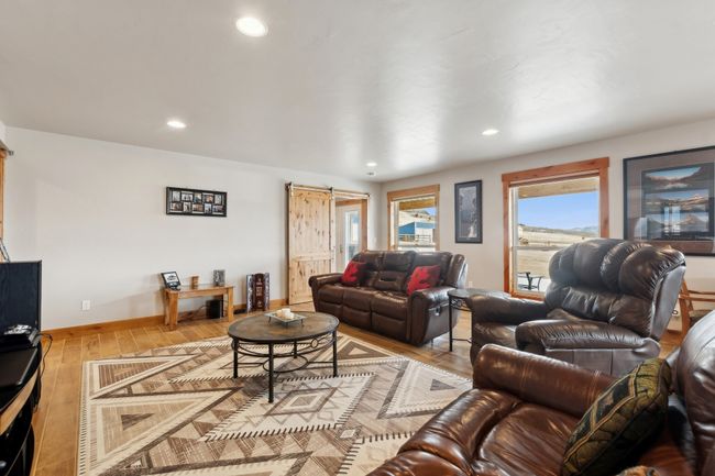 Living room with a barn door and hardwood / wood-style flooring | Image 31