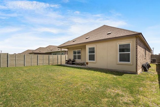 Back of property featuring a patio, a lawn, a shingled roof, and a fenced backyard | Image 26