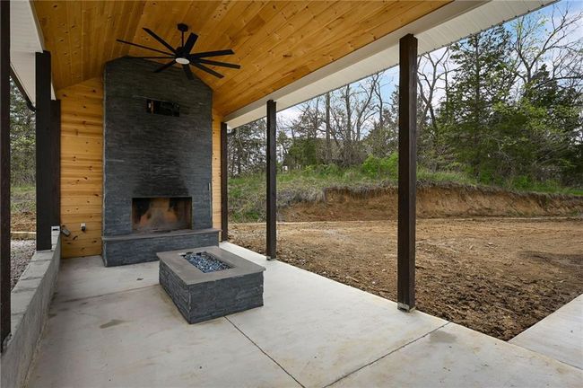 View of patio / terrace featuring an outdoor stone fireplace. | Image 56