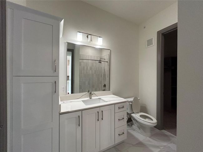 Bathroom with a tile shower, vanity, and toilet | Image 13
