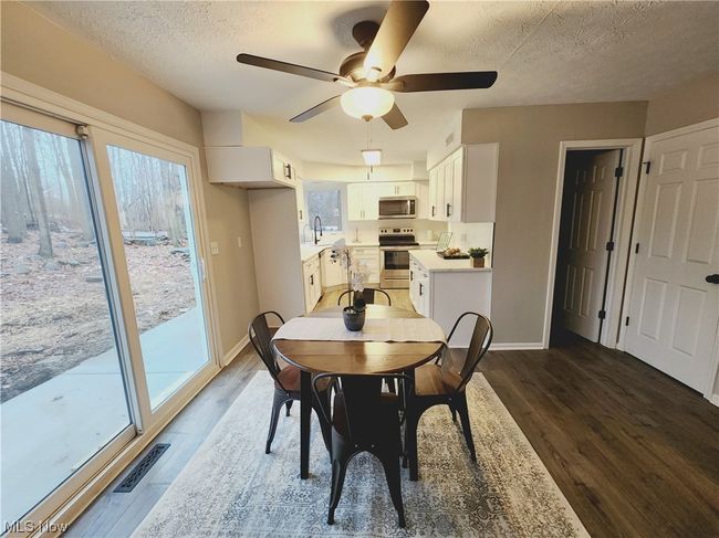 Dining space featuring dark wood-type flooring, ceiling fan, a textured ceiling, and sink | Image 13