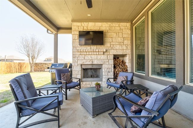 View of patio / terrace with an outdoor living space with a fireplace, area for grilling, and fence | Image 33