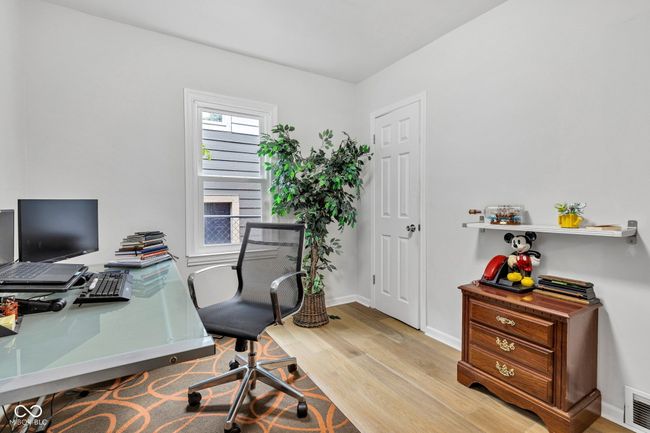 Main floor bedroom utilized as office space with abundant closet storage including functional shelving. | Image 19