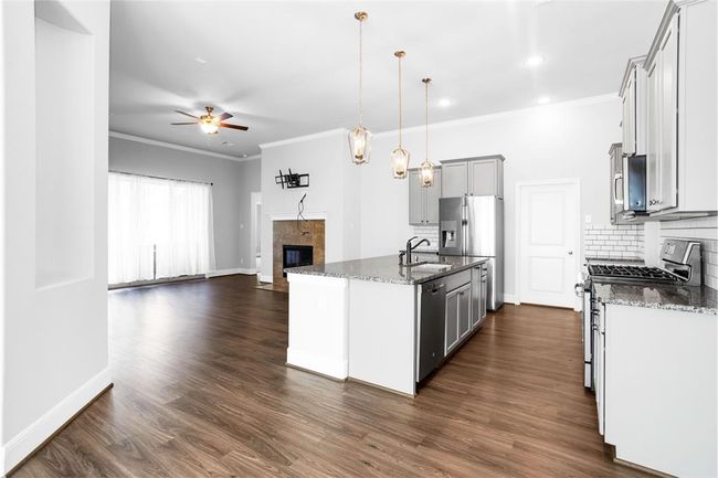Spacious open-concept kitchen featuring sleek stainless steel appliances. | Image 10