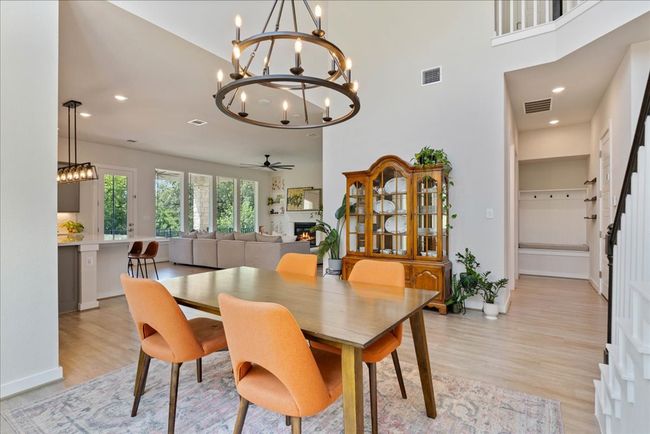 Dining room with visible vents, light wood-style flooring, and a lit fireplace | Image 7