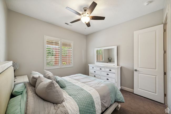 Bedroom with dark carpet, visible vents, a ceiling fan, and baseboards | Image 21
