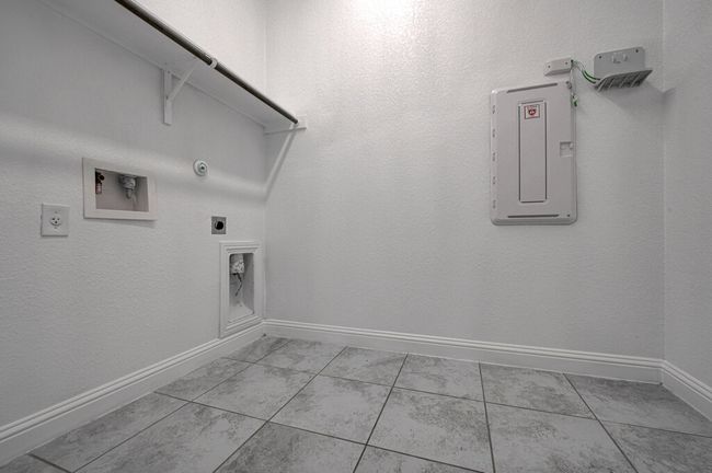 Washroom featuring hookup for a gas dryer, hookup for an electric dryer, washer hookup, and electric panel | Image 17