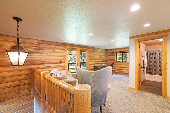 upstairs Living area featuring a textured ceiling, recessed lighting, baseboards, carpet floors, and rustic walls | Image 23