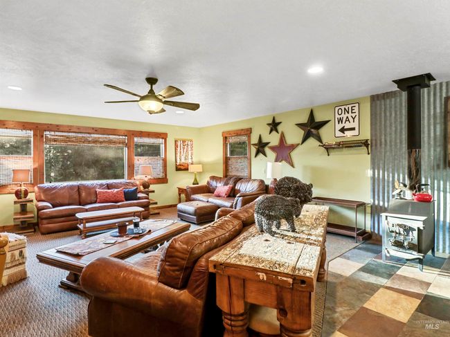 Carpeted living area with a wood stove, ceiling fan, and recessed lighting | Image 22