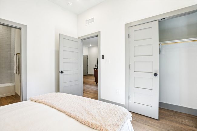 Bedroom featuring light wood-type flooring, a closet, and connected bathroom | Image 15
