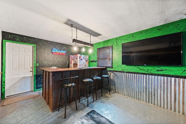 Bar featuring a bar and freestanding refrigerator | Image 30