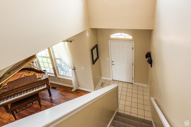 Tiled foyer entrance featuring a high ceiling and baseboards | Image 15