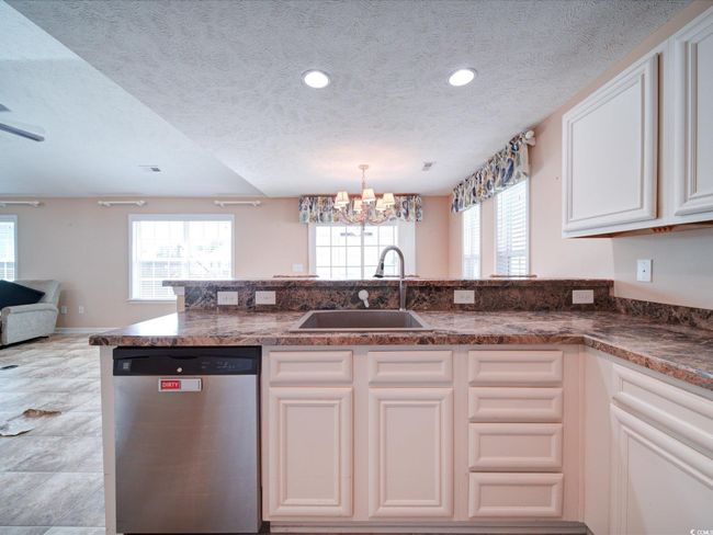 Kitchen featuring dishwasher, a chandelier, a textured ceiling, healthy amount of natural light, and open floor plan | Image 19