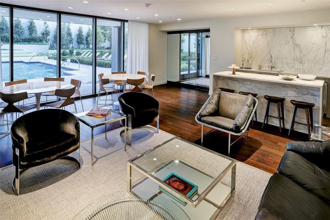 Casual community entertaining and conversation area with a coffee bar and game tables overlooking the pool. | Image 32