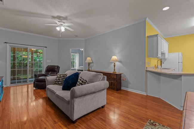 Living area featuring light wood-style floors, ceiling fan, crown molding, baseboards, and recessed lighting | Image 18