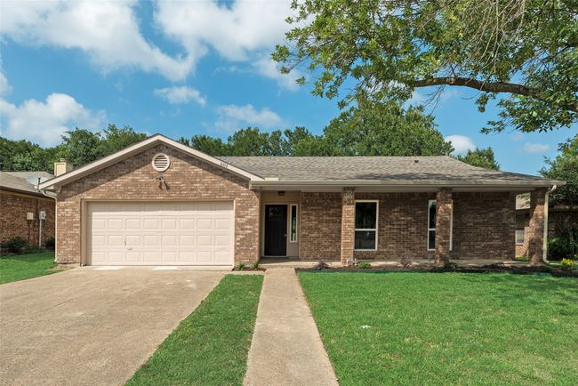 Single story home with driveway, a front lawn, brick siding, an attached garage, and roof with shingles | Image 4