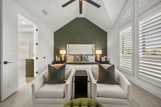 Carpeted bedroom with vaulted ceiling, wooden walls, a ceiling fan, and recessed lighting | Image 21