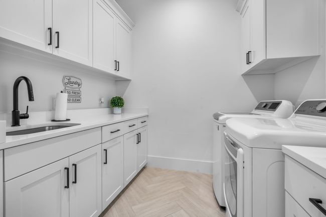 Laundry room featuring washing machine and dryer, cabinet space, and baseboards | Image 31