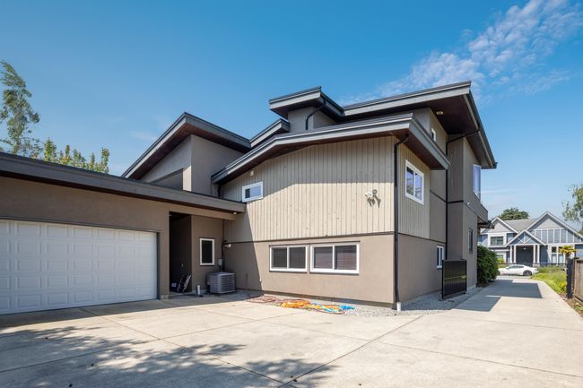 View of front of property featuring concrete driveway, central AC unit, a garage, and stucco siding | Image 38
