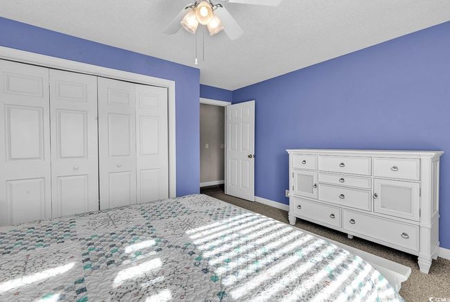 Bedroom with a closet, carpet flooring, baseboards, and a ceiling fan | Image 13