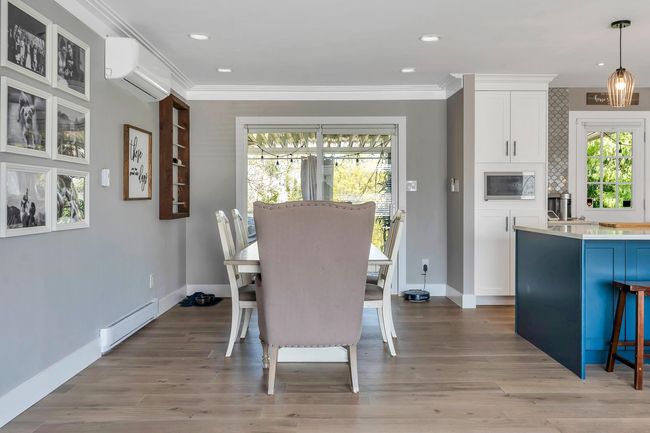 Dining area featuring a wall unit AC, light wood finished floors, a baseboard heating unit, and baseboards | Image 15