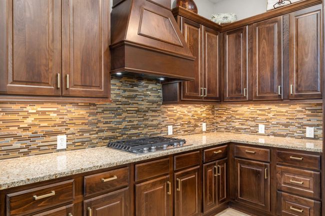 Another shot of your beautiful kitchen showcasing the gas range cooktop, tile backsplash, dark stained cabinets and plenty of outlets for all your kitchen gadget needs. | Image 15