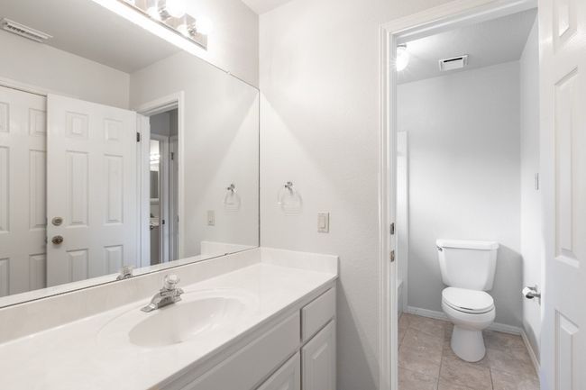 Bathroom with vanity, toilet, baseboards, and tile patterned floors | Image 40
