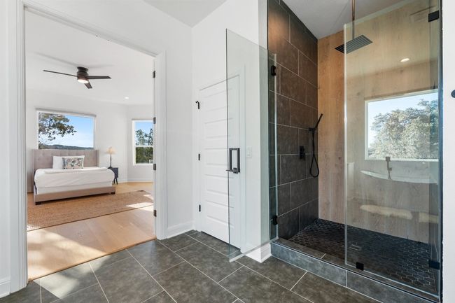 The primary ensuite luxury bath on the main level is a true retreat, offering a double vanity, walk-in closet, spa-like bath with a designer rain shower, and a freestanding tub. | Image 21