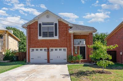 View of front facade featuring a front yard and a garage | Image 1