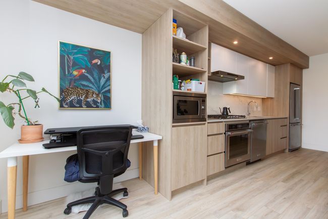 Kitchen with light wood-style floors, modern cabinets, appliances with stainless steel finishes, and open shelves | Image 10