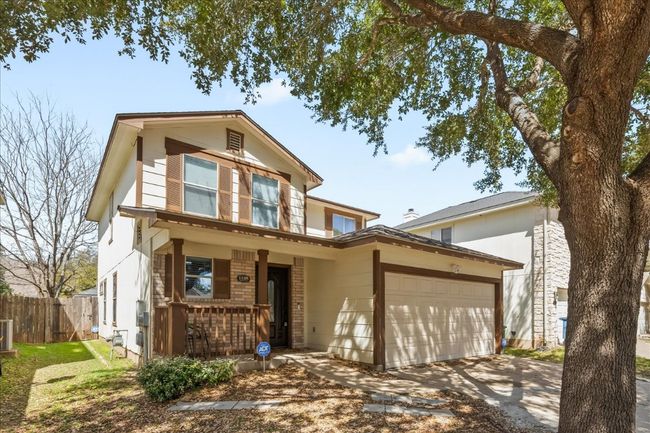 Traditional-style home featuring fence, covered porch, central AC, concrete driveway, and a garage | Image 6
