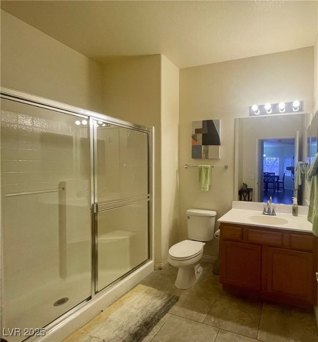 Full bath featuring tile patterned flooring, toilet, a shower stall, and vanity | Image 42
