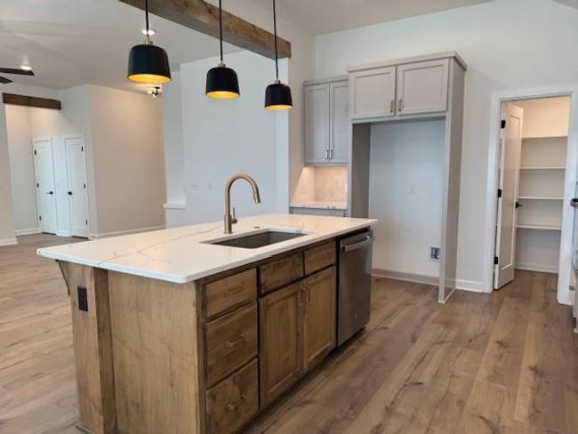 Kitchen with a center island with sink, light wood-type flooring, stainless steel dishwasher, and a sink | Image 10