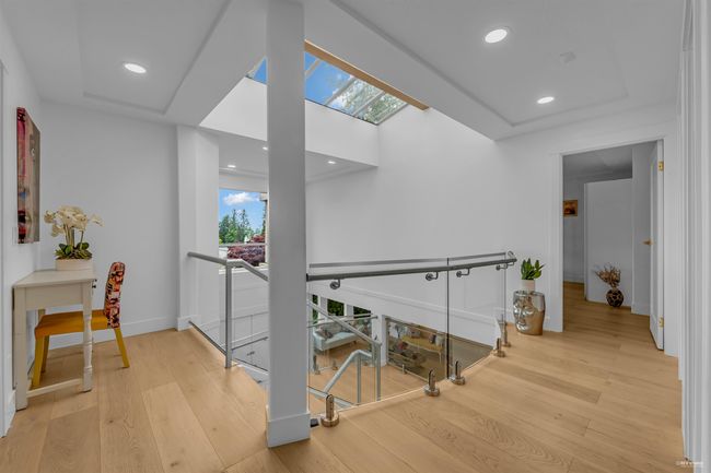 Hallway featuring an upstairs landing, a skylight, wood finished floors, baseboards, and recessed lighting | Image 14