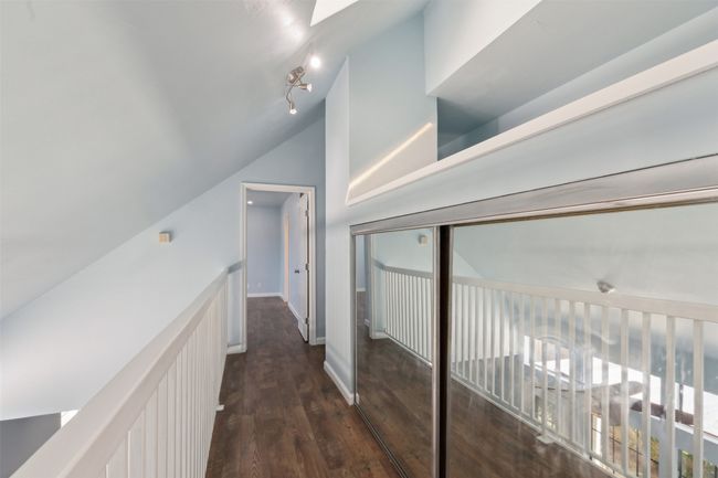 Corridor featuring lofted ceiling, baseboards, and wood finished floors | Image 20
