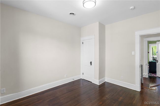 Unfurnished room featuring baseboards, visible vents, and dark wood-style floors | Image 26