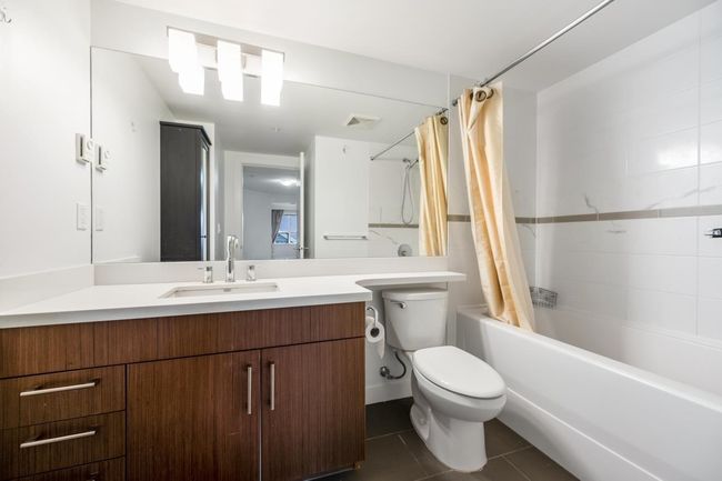 Bathroom featuring tile patterned flooring, shower / bath combo with shower curtain, and vanity | Image 17