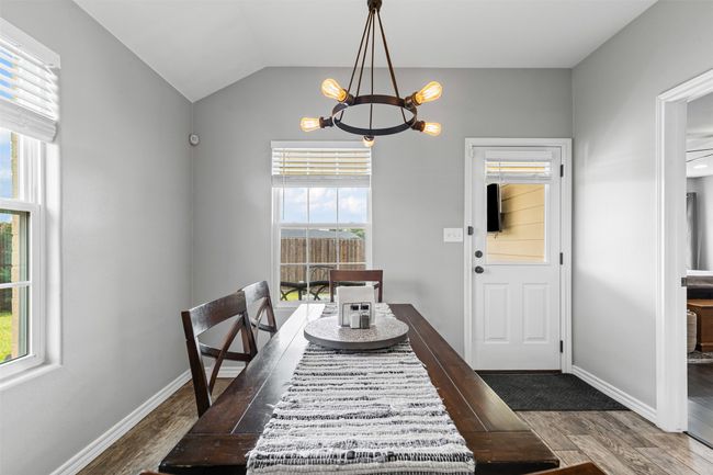 Dining room with a chandelier, wood finished floors, plenty of natural light, baseboards, and lofted ceiling | Image 16
