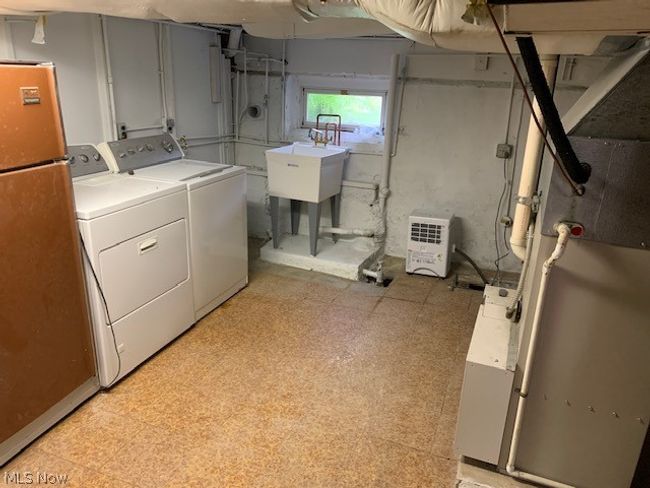 Clothes washing area with washer and clothes dryer, sink, and light tile flooring | Image 16