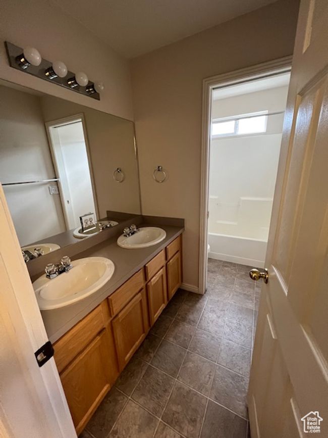 Full bathroom with double vanity, a sink, and tile patterned floors | Image 9