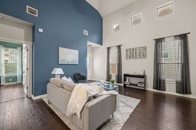 Living area with high vaulted ceiling, baseboards, and hardwood / wood-style floors | Image 7