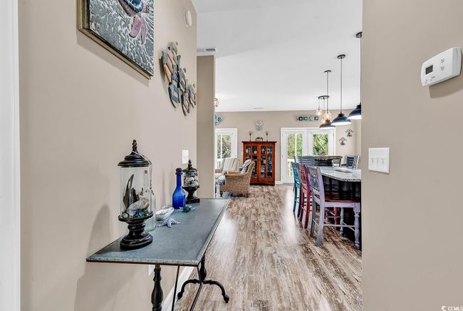 Kitchen with white cabinetry, light wood-style flooring, stainless steel appliances, and backsplash | Image 15