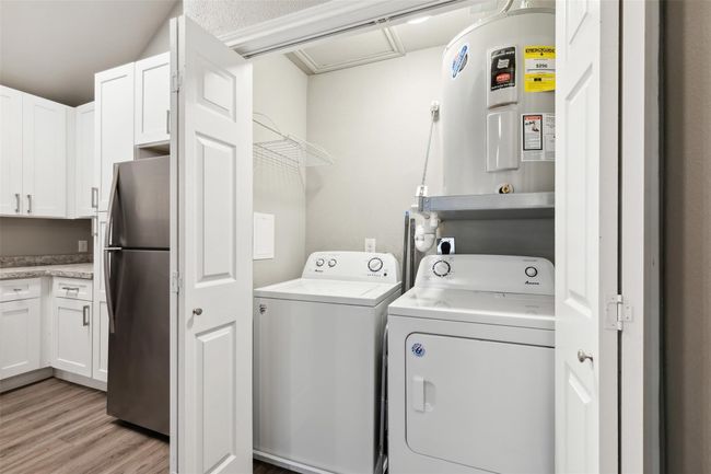 Laundry area featuring washer and clothes dryer and light wood finished floors | Image 16