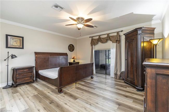 Bedroom with visible vents, ceiling fan, light wood-style floors, and ornamental molding | Image 18